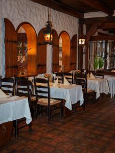 a restaurant with tables and chairs with white table cloth at Heidehotel Waldhütte in Telgte