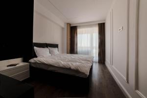 a bedroom with a bed and a window at Cherry Apartments in Iaşi