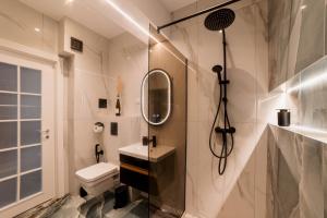 a bathroom with a sink and a shower and a toilet at Cherry Apartments in Iaşi +5 photos