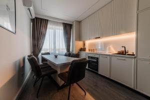 a kitchen with a table and chairs in a room at Cherry Apartments in Iaşi