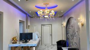 a room with a desk with a computer and a chandelier at Contact Hôtel Le Continental in Vierzon