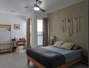a bedroom with a bed with a ceiling fan and a desk at Bokatrip Xochimilco in Oaxaca City