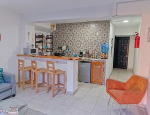 a kitchen with a counter and chairs in a room at Bokatrip Xochimilco in Oaxaca City