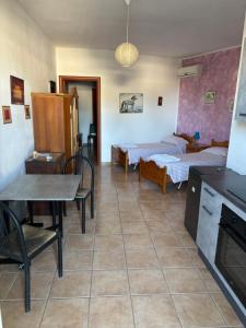 a room with two beds and a table and chairs at Vento Dell'Est in San Cataldo +39 photos
