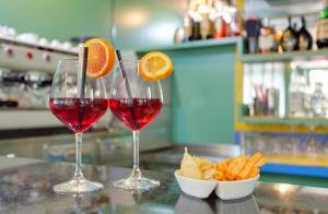 two glasses of red wine and a bowl of orange slices at Nautilus Hotel in Bellaria-Igea Marina