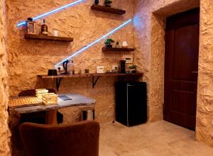a room with a wall with a refrigerator and a table at suite pompei La Caverna in Pompei +6 photos