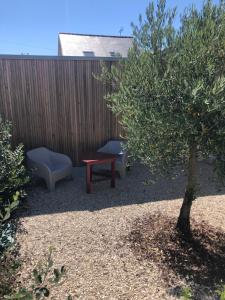 a garden with a bench and a table and a chair at Le logis de Niort Appart Hôtel Le bis in Niort