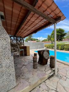 a patio with a table and a swimming pool at Canto da Ita - Próxima a praia com piscina e churrasqueira in Itamaracá