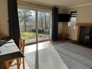 a living room with a large sliding glass door at Coiseag at Maol Ruadh, Roy Bridge, near Ben Nevis in Roybridge