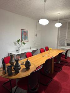 a conference room with a large wooden table and red chairs at Le Saint Christophe in Cosne-Cours-sur-Loire