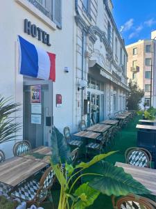 a row of tables and chairs in front of a hotel at Le Saint Christophe in Cosne-Cours-sur-Loire