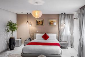 a bedroom with a large bed with red pillows at Eterniti by Amber in Lagos