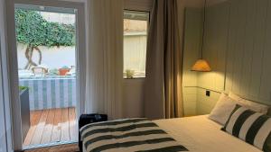 a bedroom with a bed and a door to a balcony at Boutique Hôtel Le Clos Huguerie - Bordeaux Centre in Bordeaux +95 photos