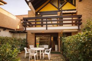 a patio with a table and chairs in front of a house at Beach House Riviera in Lignano Sabbiadoro