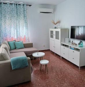 a living room with a couch and a tv and a table at Alojamiento rural El Membrillo in Almodóvar del Río