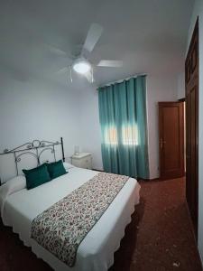 a bedroom with a large bed with green curtains at Alojamiento rural El Membrillo in Almodóvar del Río