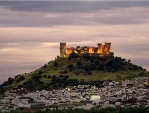 a castle on top of a hill with a city at Alojamiento rural El Membrillo in Almodóvar del Río