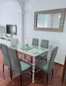 a dining room table with chairs and a mirror at Alojamiento rural El Membrillo in Almodóvar del Río