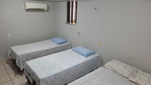 a room with three beds and a window at Vera's Apart-Hotel & Restaurante in Belém