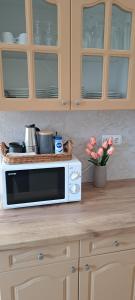 a kitchen counter with a microwave and a vase of flowers at Villa Maria in Egerszalók