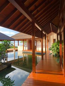 a house with a wooden deck and a swimming pool at Canta La Rana in Bejuco