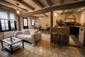 a living room with a couch and a kitchen at Le Cottage des Chalands - classé 3 étoiles in Saint-Georges-sur-Cher
