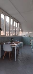 a room with a table and a chair and windows at La casa di Ely in Sarno +1 photo