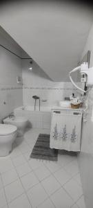 a white bathroom with a toilet and a sink at La casa di Ely in Sarno