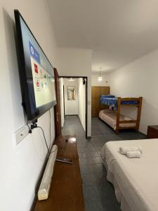 a room with a tv and a bedroom with two beds at Ana y Fran in Villa Zorraquín