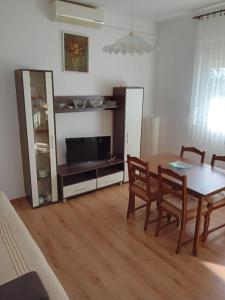 a dining room with a table and a tv at Dume in Povljana