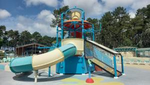 a water slide at a playground at Sous les Pins dans camping 4 étoiles MH familial 322 6 à 8 couchages 2 salles de bain 2 WC in Saint-Julien-en-Born