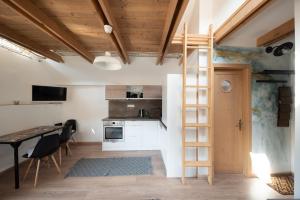a room with a ladder and a kitchen with a table at Vörösdió apartment house in Szilvásvárad