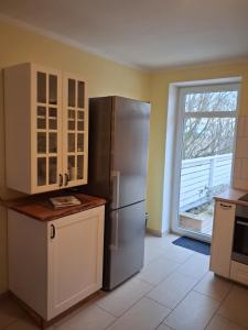 a kitchen with a stainless steel refrigerator and a window at Strandrose in Friedrichskoog