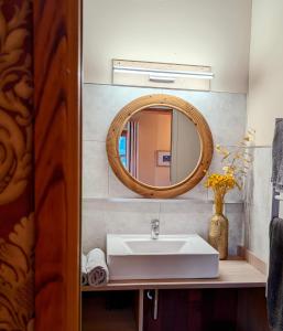 a bathroom with a sink and a mirror at Chambres d'Hôtes Barraconu in Porto-Vecchio