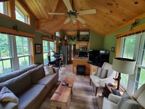 a living room with a couch and a ceiling fan at Bison Farm - Cabin "Vieja" in Culpeper
