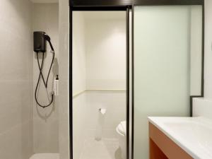 a bathroom with a shower and a toilet at Fortune D Hotel Maesot in Mae Sot +8 photos