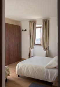 a bedroom with a white bed and a window at Agriturismo San Germano in San Vittorino