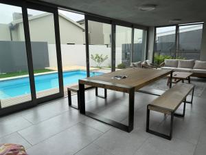 a living room with a table and a pool at 22 Mountain View in Herolds Bay +9 photos