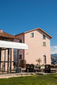 a building with a white awning and benches in front at Agriturismo San Germano in San Vittorino