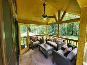 a screened in porch with couches and a ceiling fan at Bison Farm - Cabin "Vieja" in Culpeper +5 photos