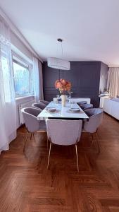 a dining room with a white table and chairs at Panorama Apartment in Nowy Targ +27 photos