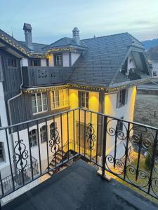 a large yellow and white house with a balcony at Black Cockatoo Lodge close to Bern and Thun in Oberdiessbach