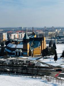 a large building with a clock tower in the snow at Loft Re Design Apartament in Głogów