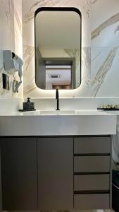 a bathroom with a sink and a mirror at Studio Red 10 - Sorocaba in Sorocaba