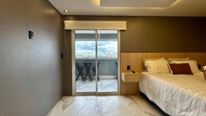 a bedroom with a bed and a view of a balcony at Studio Red 10 - Sorocaba in Sorocaba