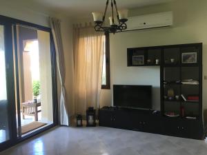 a living room with a tv and a large window at Villa at Marassi - Verona in El Alamein