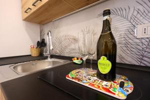 a bottle of wine and a wine glass on a kitchen counter at Kyma Apartment - Giardini Naxos in Giardini Naxos +11 photos
