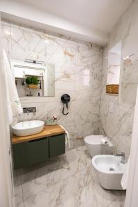 a white bathroom with a sink and a toilet at Kyma Apartment - Giardini Naxos in Giardini Naxos