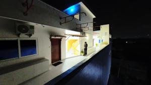 a man standing on the side of a building at night at Captain Purunchi in Cotonou