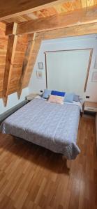 a bedroom with a bed in a room with wooden floors at Cabaña Alpina 2 in Coñaripe